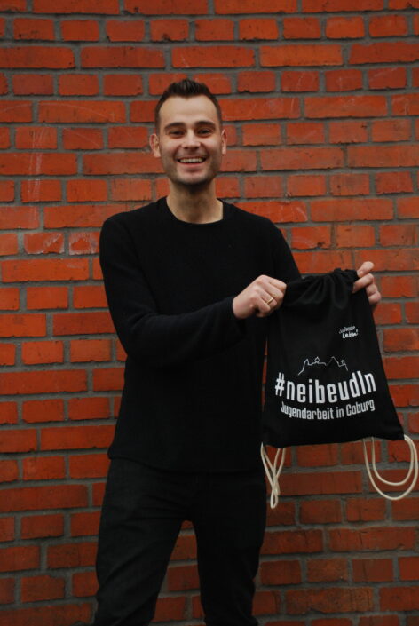 Mark Ritschel (JuZ Domino) präsentiert freudig die voll gepackten Beutel Mark Ritschel präsentiert einen der Turnbeutel, den sich Jugendliche in den Jugendzentren abholen können.